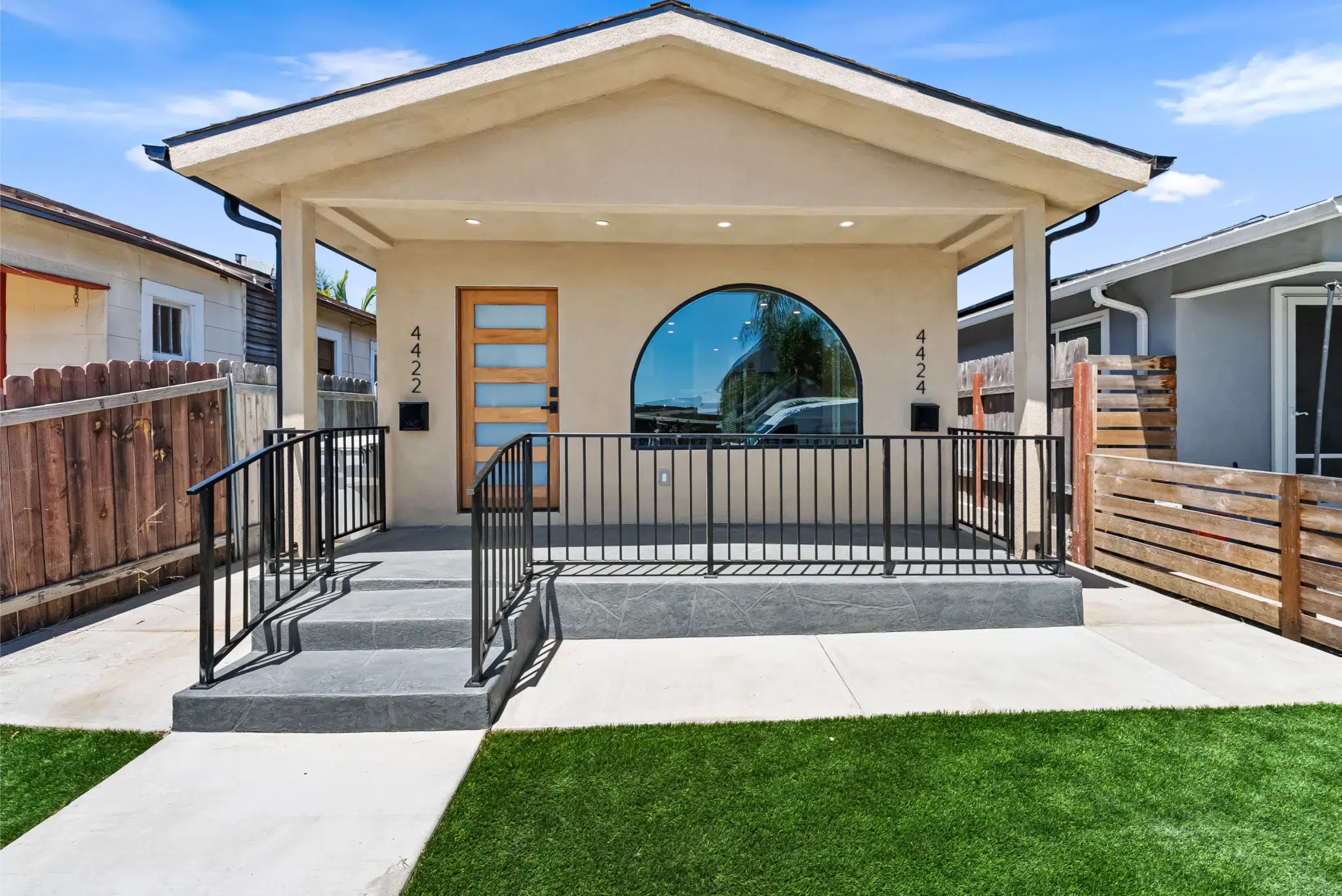 Remodeled Cherokee Avenue home exterior with new stucco, arched entry, and porch, San Diego
