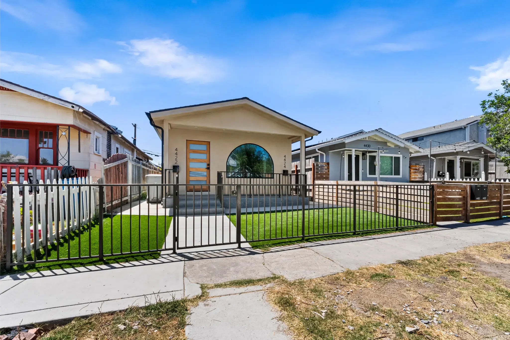 Front exterior of the remodeled Cherokee Avenue home with a fenced yard, San Diego