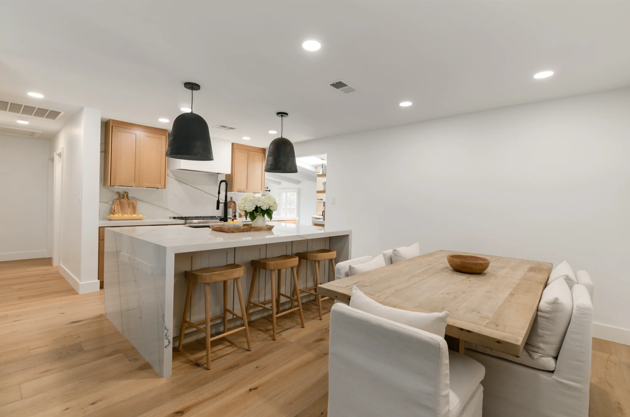 Bright warm-modern kitchen remodel with white oak cabinets and a waterfall quartz island on Wisteria Drive, San Diego