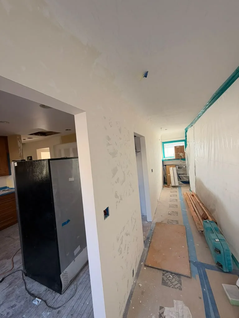 Interior remodel in progress by MEE Builders, with new drywall and taped floor protection