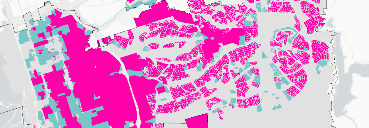 A cadastral or zoning map showing a municipality with different land parcels color-coded in bright magenta/pink, light blue/cyan, and gray. The pink areas appear to represent one classification of land use or ownership, while cyan areas indicate another category, set against a gray background showing the broader municipal context. The map displays detailed property boundaries with individual plots clearly delineated, particularly dense in the eastern residential areas and more consolidated in the western portion.
